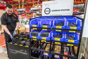 Supply Technologies team member managing assembly components at a point-of-use Kanban station in a manufacturing facility.
