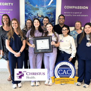 Group of healthcare workers smiling and holding a framed certificate in a hospital setting with CHRISTUS Health and CAC logos.