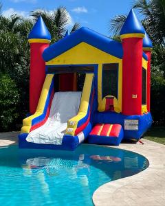 Bounce house with slide by pool