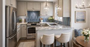 Small kitchen remodel with blue picket tile backsplash, gray cabinets, granite counters, and peninsula seating