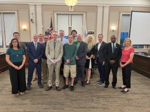 Jim Dolan, Ethan Zolit, Mayor Jake Wilson, and Councillor Matt McLaughlin gather with DM community members at Somerville City Hall.