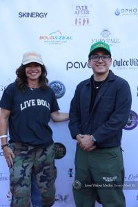 Erica and Mikos on the red carpet wearing Live Bold Trucker