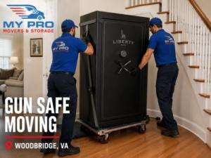 Two MyProMovers movers carefully transporting a heavy gun safe into a residential home during a professional move.