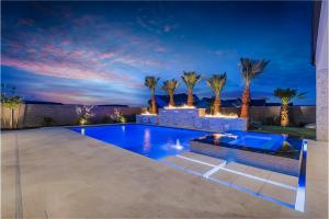 Twilight view of a custom pool with fire bowls, raised wall, and covered ramada built by Paragon Pools in St. George, Utah