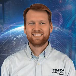 The image is a photo of TMC Technologies Vice President - National Security Division, Dr. Eric Mohan