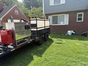 Newman's Plumbing branded HydroVac excavation trailer parked at a residential job site