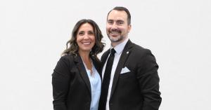 Brian and Elizabeth Ward of 5W&Co standing together in dark business suits against a plain white background