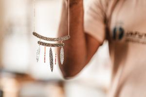 A hand holding up a piece of hand-crafted jewellery