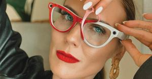 Woman with red lipstick lifting a red PaprDoll wrap off her Ray-Ban Meta smart glasses.