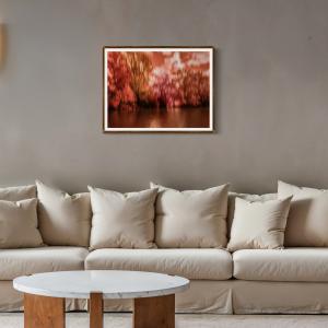 Red and burgundy ICM abstract woodland fine art print displayed above a neutral sofa in a contemporary living room.