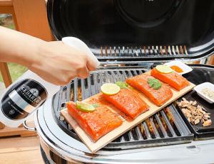 Wooden planks for food grilling photographed in real time to show a lifestyle of how it is used while grilling salmon fillets outdoors