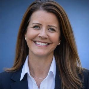 smiling female executive wearing blue suit and collared shirt