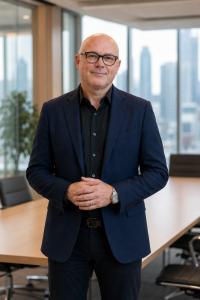 Andrew Buzinsky standing in a boardroom with his hands folded