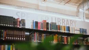 Photo of interior with book stacks and the words “Spencer Library” embossed on the wall