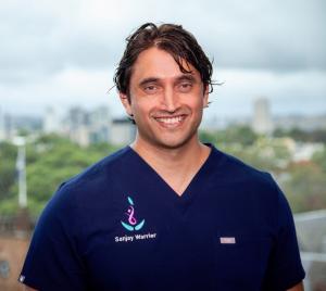 A/Prof Sanjay Warrier wearing medical scrubs.