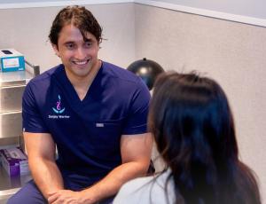 A/Prof Sanjay Warrier speaking with a woman during a medical consultation.