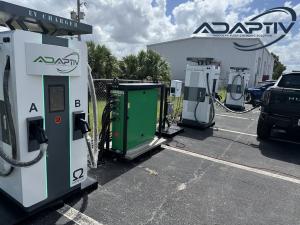 Adaptiv charging equipment with multiple OMEGA chargers and an electric truck at an outdoor depot.
