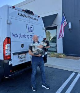 Keevin Blue with a KCB Plumbing service van with his dog.