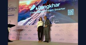 Santiago Paradela, of Gangkhar, on stage with the Technology Enabler award at the 2026 AIP Awards, beside the Gangkhar logo and the tagline Climb Higher. Protect Smarter. on the screen behind.