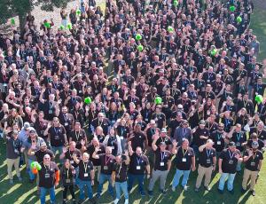 A photo of a group of employees waving at the camera
