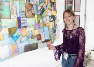young artist holding a quilted fabric piece