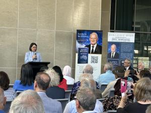 Gladys Berejiklian speaking at the launch of Philip Ruddock's book. Behind her are banners with the book cover