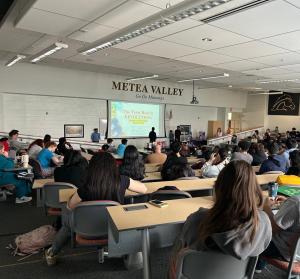 The Holistic Kids present to students at Metea Valley High School, with The Teen Health Revolution featured on the presentation screen.