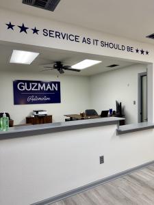 Guzman Automotive technician wearing a Guzman Automotive shirt performing an electrical diagnostic test inside a minivan.