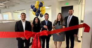 Five team members stand behind a red ribbon during the ribbon-cutting ceremony for The Injury Justice Firm at The Work Justice Firm’s expanded Los Angeles office.