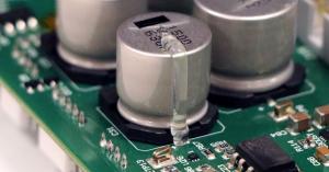 Close up of Dymax staking adhesive applied to a printed circuit board component to secure it