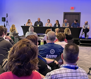 CHM patients and family members sit in an audience during a Q&A session with a panel of doctors at the front of the room.