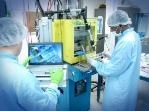 Close-up of an injection molding machine producing polymer drug delivery components at ProMed Pharma's manufacturing facility.