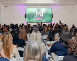 Many guests look at a screen labeled [M] Factor 2 Experience at Loopwell this past March.