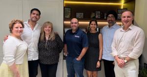 Seven BARE International leaders standing together indoors during the Mumbai meeting.