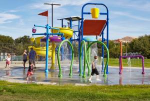 Children and families playing at a colorful community splash park built by Anderson Poolworks in Oregon