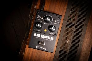 Images shows the La Brea analog tape drive pedal sitting on top of a vintage tape machine