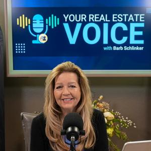 Real estate expert Barb Schlinker inside her Colorado Springs podcast studio hosting YOUR REAL ESTATE VOICE. Digital screen displays show branding supporting her Your Home Sold Guaranteed Realty firm and local Barb Has The Buyers marketing channels.