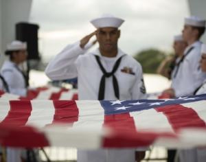 Sailors from Joint Base Pearl Harbor-Hickam Navy Honors and Ceremonies Detachment prepare the American flag for presentation at the USS Arizona Memorial in Pearl Harbor, Hawaii