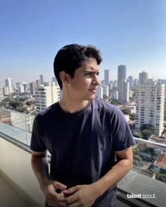 Latin American marketing specialist on a balcony overlooking a city skyline, Talent Scout logo