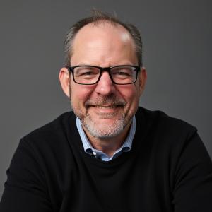 Headshot of Carl Lee Tolbert, founder of Wayward Leaders, [smiling, in a dark jacket, against a plain background]
