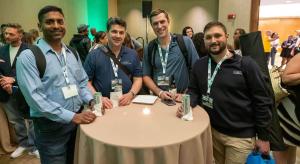 Attendees wearing event badges gather around a standing table at a Small Business Expo networking gathering.