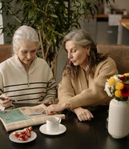 Two happy senior citizens enjoying a crossword puzzles at Ciela Senior Living Pacific Palisades CA - Rooted by Ciela