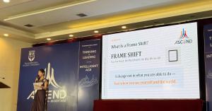 Dr. Mariko Kitamura speaking on stage in front of a slide titled "What Is a Frame Shift?" at ASCEND 2026