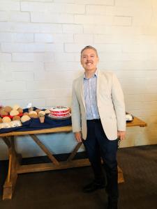 Raul Tintori standing beside a celebration table at Mavagi Enterprises