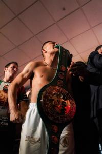 Isaac “Pitbull” Cruz stands with his championship belt during the official weigh-in face-off with Néstor Bravo ahead of their boxing match.