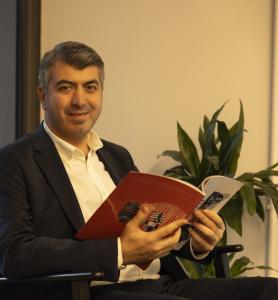 Fatih Coşkun, Founder and CEO of complead, seated in an office holding a magazine