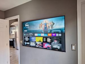 A flush-mount TV mounting El Paso installation on a grey wall beside a doorway, with all cables professionally concealed.