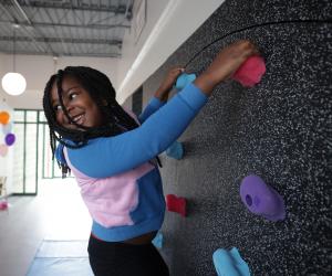 a young girl on a climbing wall