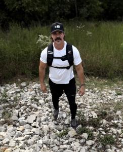 Chris Gowen wearing the Directional Force Zen-Cool cooling hydrogel weight vest while walking a rocky trail.