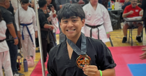 Eli Cooper holds his Weapons gold medal and Bo at the 2026 Ontario Grand Nationals Martial Arts Championships.